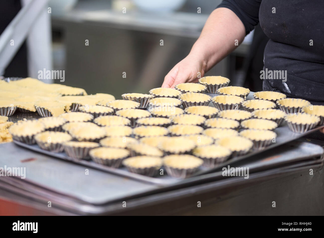 Konditor Törtchen, setzen Sie den Teig in Backformen, in der Küche der Konditorei. Stockfoto