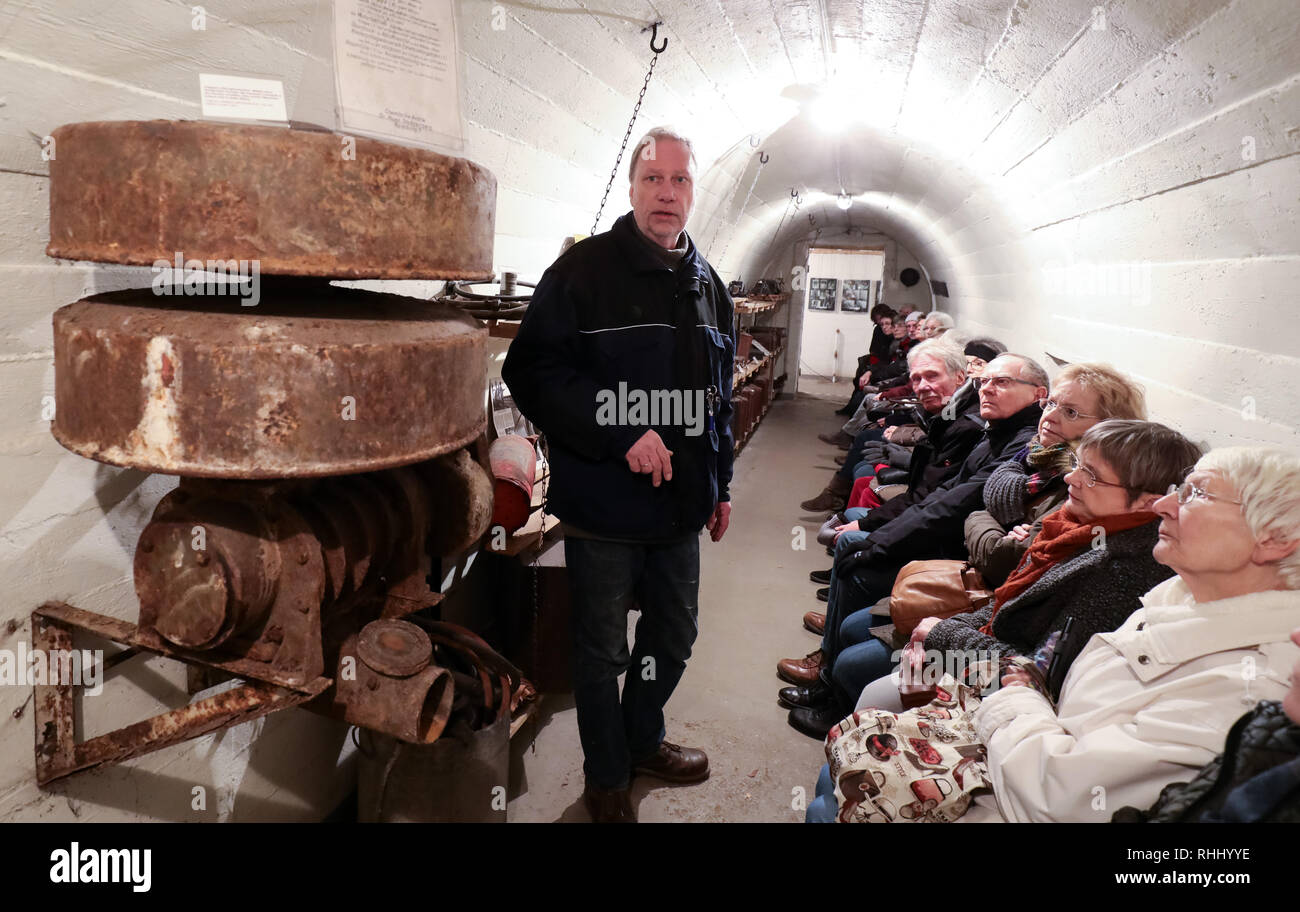 Hamburg, Deutschland. 31 Jan, 2019. Gunnar Wulf, Leiter der Bezirk Archiv in Hamburg-Hamm, spricht zu einer Gruppe von Besuchern des Hamburger Bunker Museum zusätzlich zu einer handbetriebenen Lüftung Maschine. Die röhrenförmige Bunker aus dem Zweiten Weltkrieg hat ein Museum seit 1997. (Dpa' Bunkermuseum in Hamburg - "zu spüren, wie wichtig Frieden ist'' ab 03.02.2019) Credit: Christian Charisius/dpa/Alamy leben Nachrichten Stockfoto