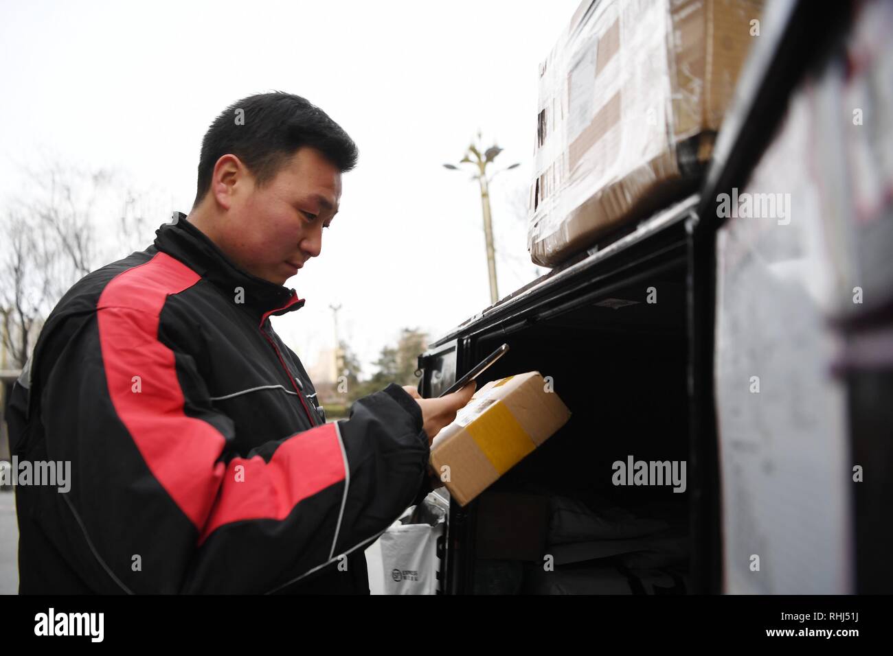 Xi'an der chinesischen Provinz Shaanxi. 3 Feb, 2019. Deliveryman Luo Feilong ruft Kunden ihre Pakete in Xi'an, die Hauptstadt der Provinz Shaanxi im Nordwesten Chinas, Feb 3, 2019 zu erhalten. Luo Feilong, eine 31-jährige deliveryman aus der Provinz Shaanxi, hat die Auslieferung von Paketen in einer Gemeinschaft von Xi'an für vier Jahre. Luo beantragt werden während der diesjährigen Frühlingsfest Urlaub, so dass andere Deliverymen außerhalb von der Provinz an ihre Heimatorte für Familienfeiern zurückkehren können. Credit: Zhang Bowen/Xinhua/Alamy leben Nachrichten Stockfoto