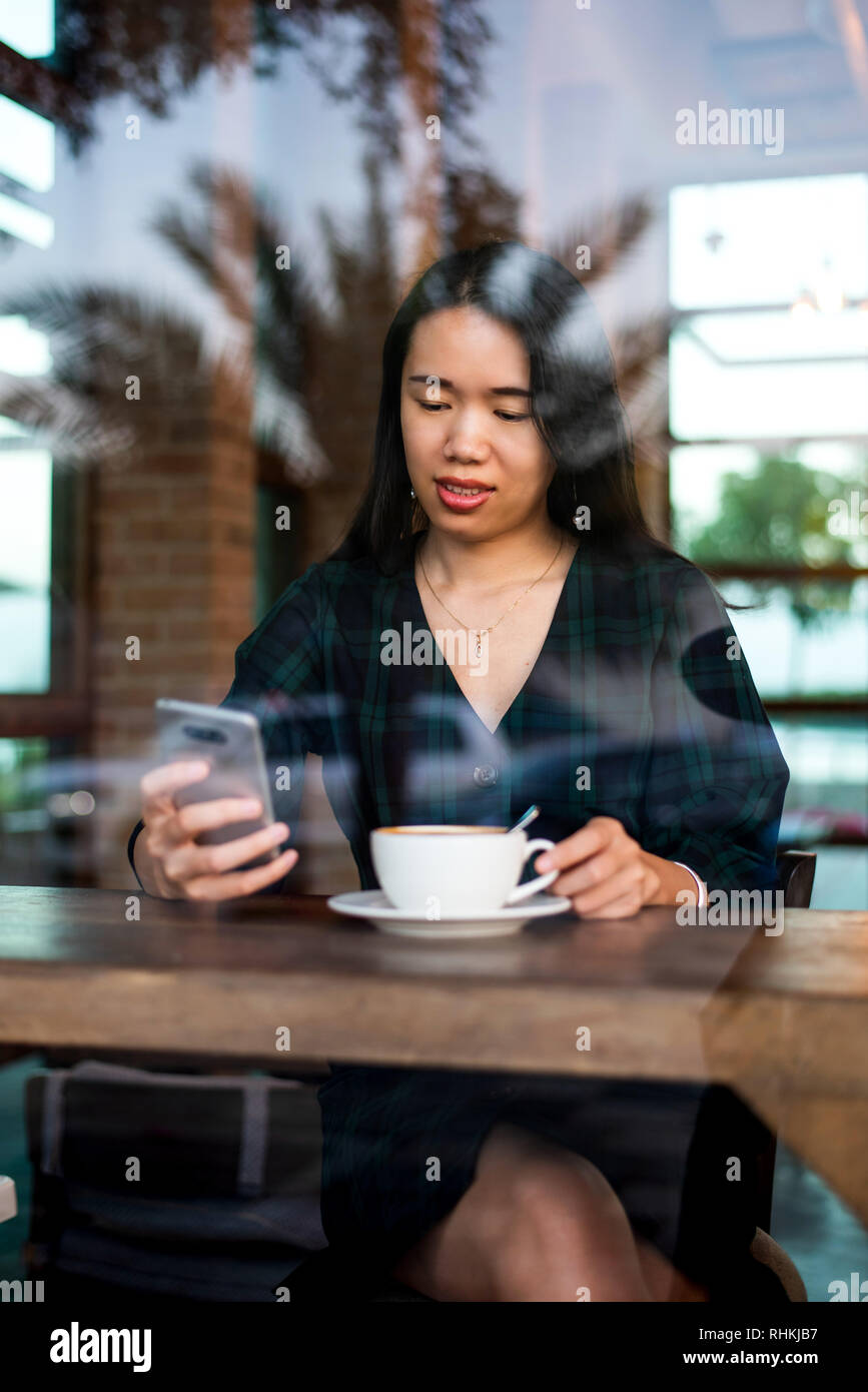 Mädchen mit einer Tasse Kaffee und mit Phone in der Bar Stockfoto