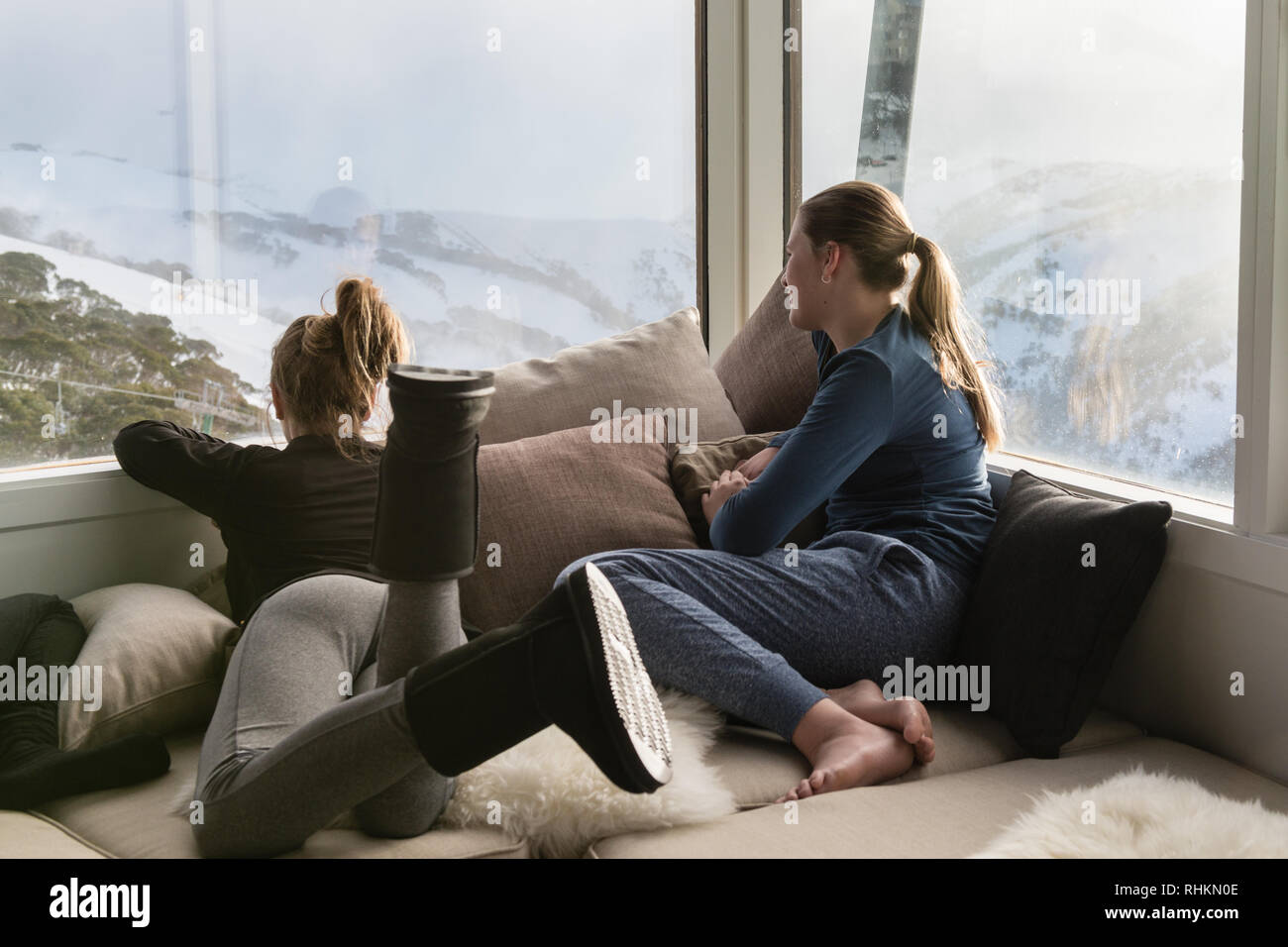 Teens in einem Chalet mit Blick auf die Winterlandschaft Stockfoto