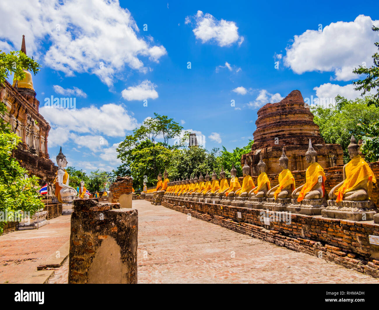 Thailand, beeindruckende Reihe von Buddha Statuen mit orange Tuniken in Ayutthaya alte Tempel Stockfoto