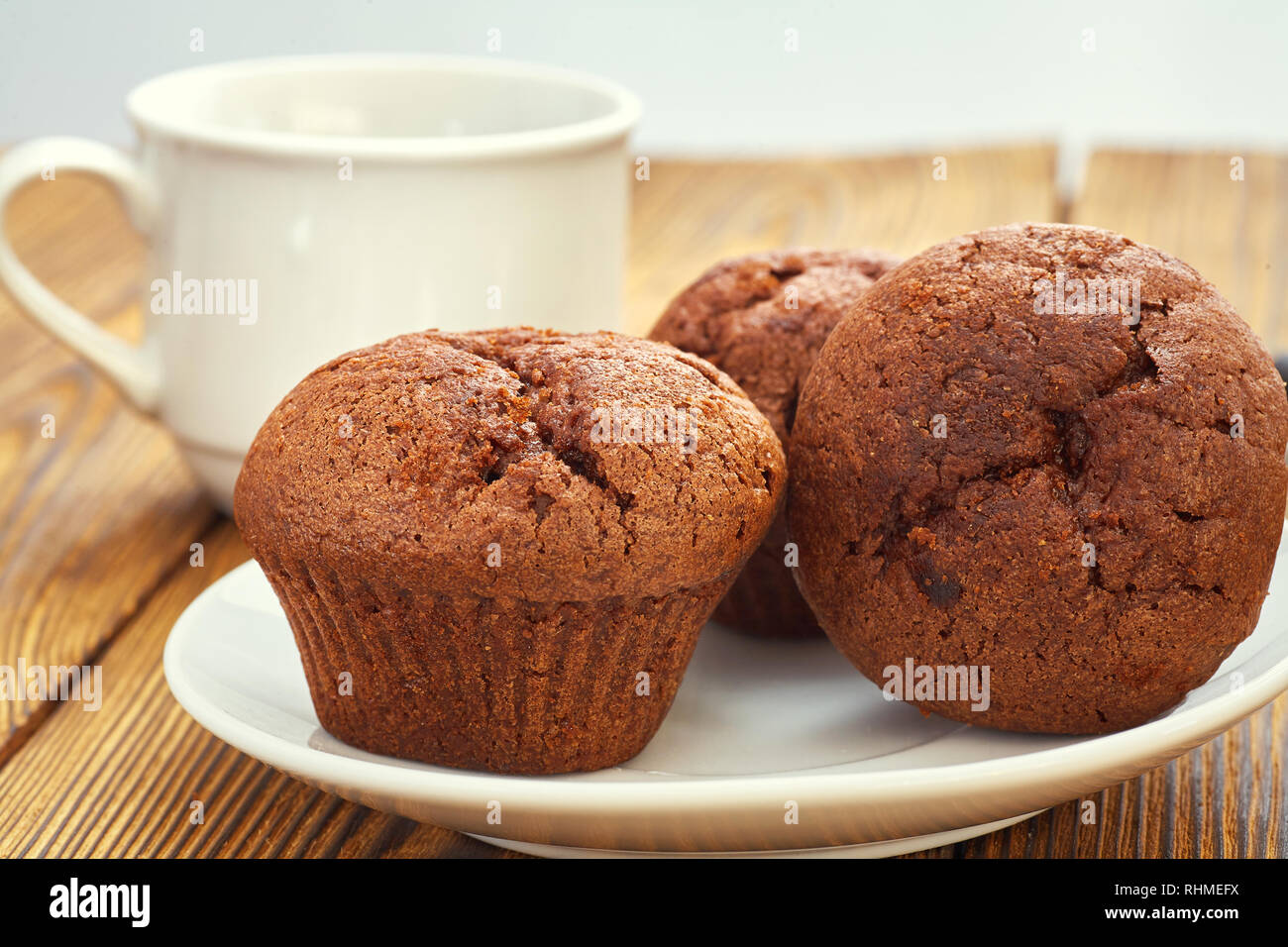 Chocolate Muffin mit dunklem Hintergrund Test auf einem alten Holztisch. Stockfoto
