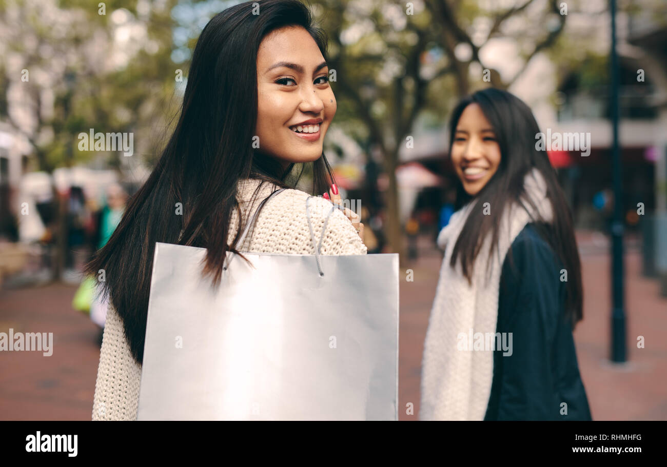 Ansicht der Rückseite zwei asiatische Frauen in der Straße zum Einkaufen. Lächelnde Frauen in die Stadt zum Einkaufen. Stockfoto