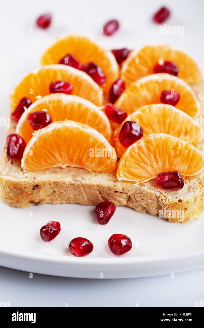 Sandwich mit Granatapfel Körner und Mandarinen auf weißen Hintergrund ...