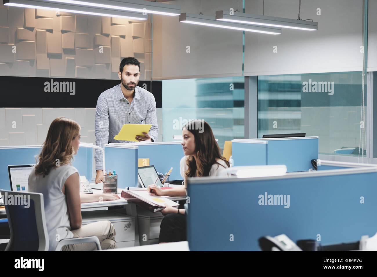 Mann bei der Arbeit ignoriert von weiblichen Kollegen in Coworking Space Stockfoto