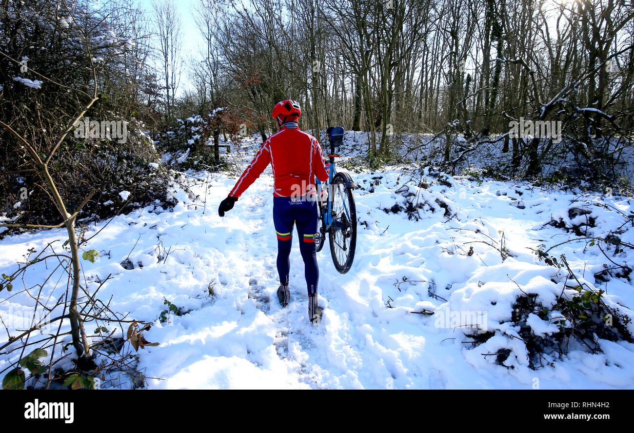 Radfahrer können ihre Fahrräder durch Schnee in Walderslade, Kent, England sah die kälteste Nacht des Winters so weit wie Temperaturen stolperten über Großbritannien. Stockfoto