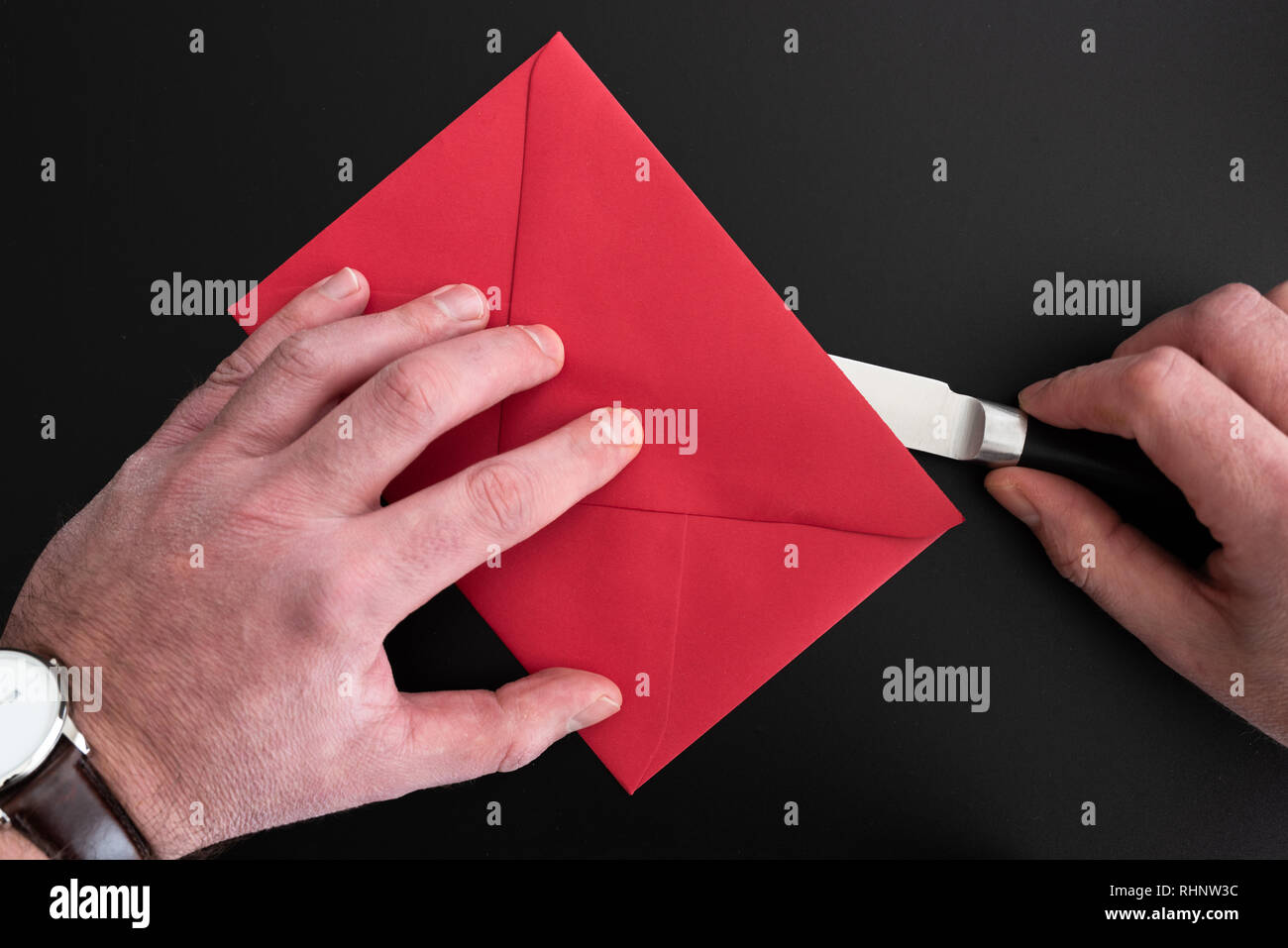 Die Hände des Menschen Eröffnung roten Umschlag mit Papier Messer Stockfoto