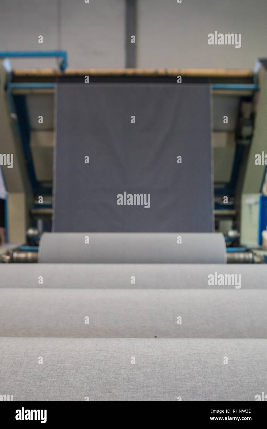 Fabric auf Textil- Maschine. Maschine für Kleidung oder gewebtes etikett in der Textilfabrik. Stockfoto