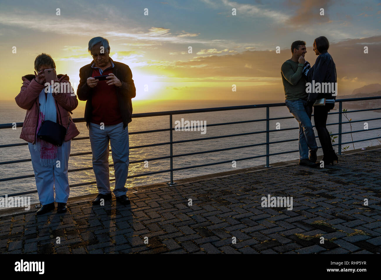 Zwei Paare, ein junges Paar und ein Paar mittleren Alters, an der Cristo Rei Sicht bei Sonnenuntergang, Garajau, Madeira Stockfoto