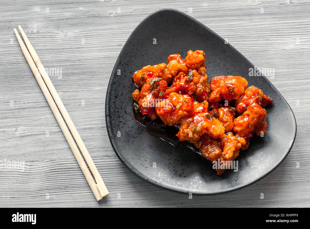 Koreanische Chinesische Kuche Ansicht Von Oben Kkanpunggi Wurziger Knoblauch Gebratene Hahnchenteile Mit Gemuse In Sussen Sosse Auf Schwarze Platte Mit Essstabchen Auf Gra Stockfotografie Alamy