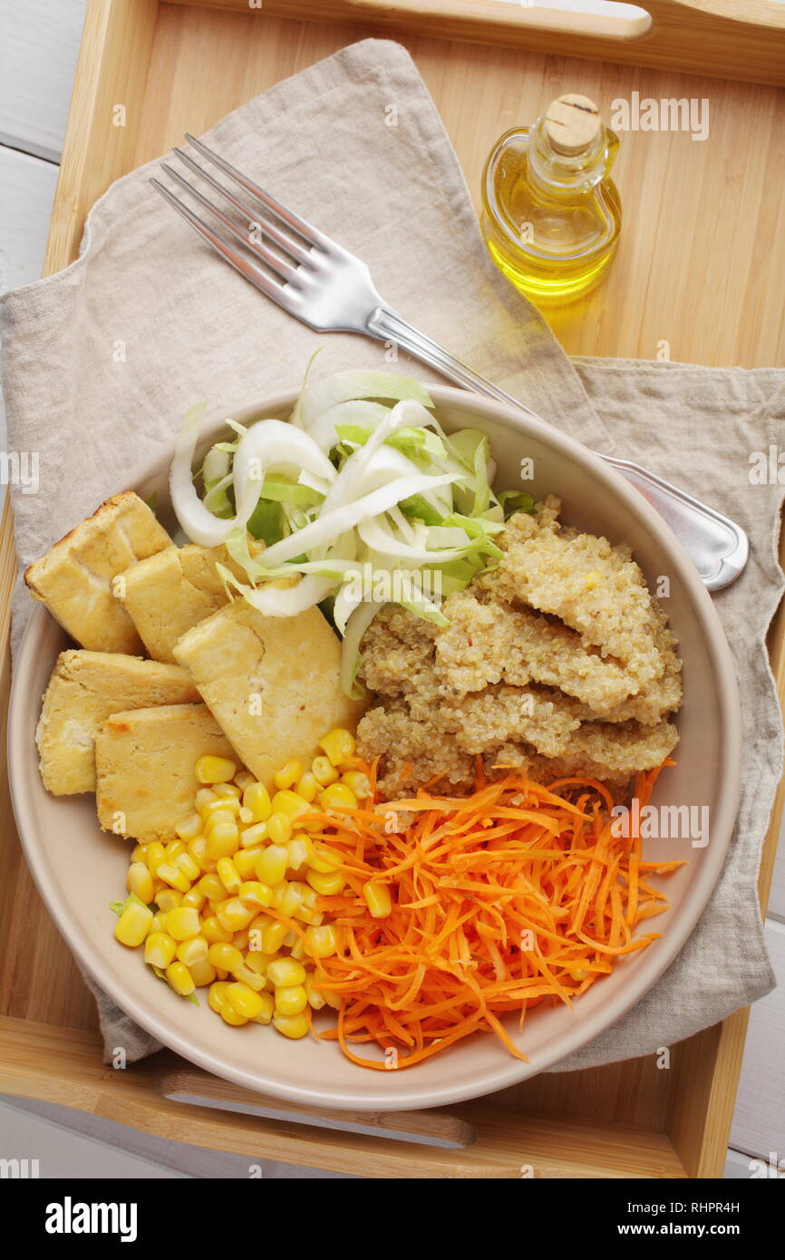 Buddha Schüssel mit Quinoa, gebratenem Tofu, Chicorée, Möhren, Mais, und Olivenöl Stockfoto