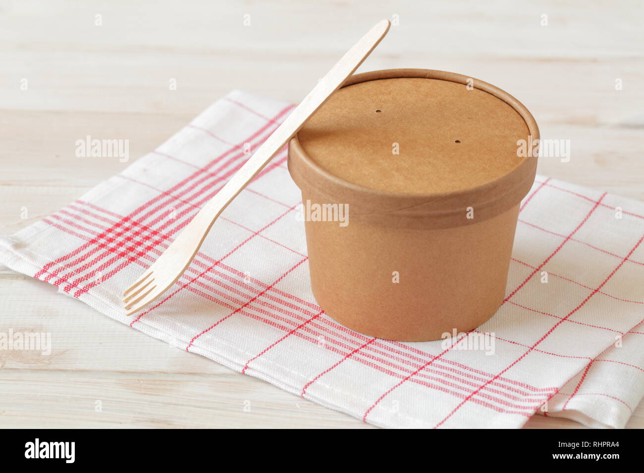 Kraftpapier Suppe Schüssel mit Deckel und Holz- gabel auf einem weißen Tisch Stockfoto