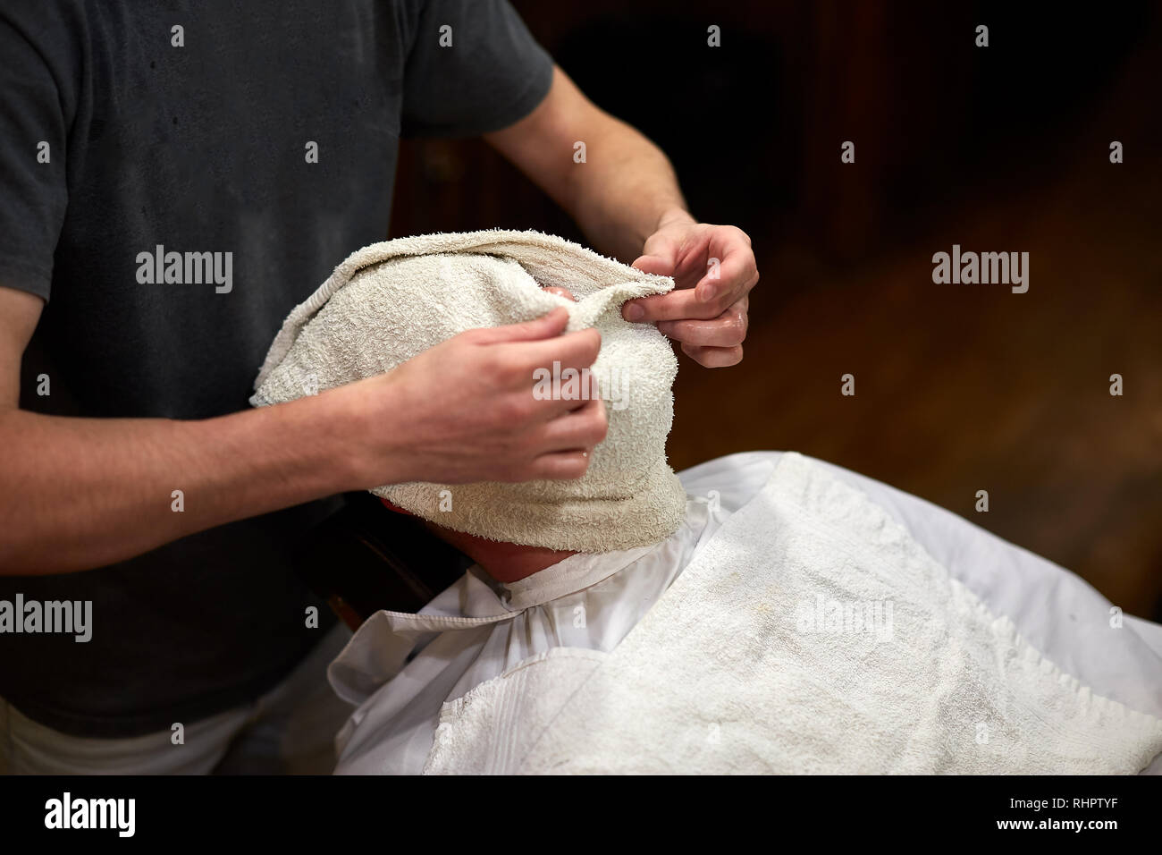 Client mit einem Handtuch vor dem Rasieren in Friseur Stockfoto