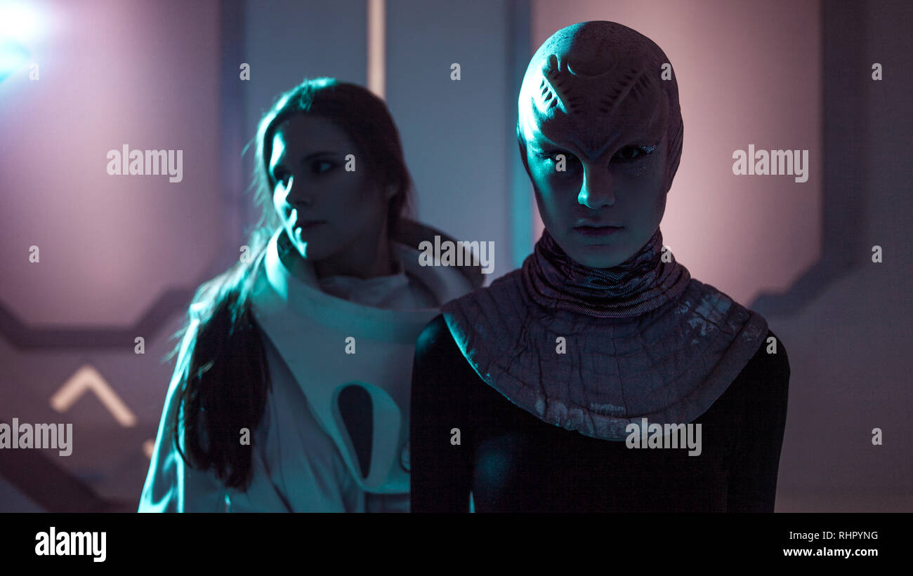 Frau und ein Alien schauen sich an. Kontakt mit anderen Zivilisationen. Stockfoto