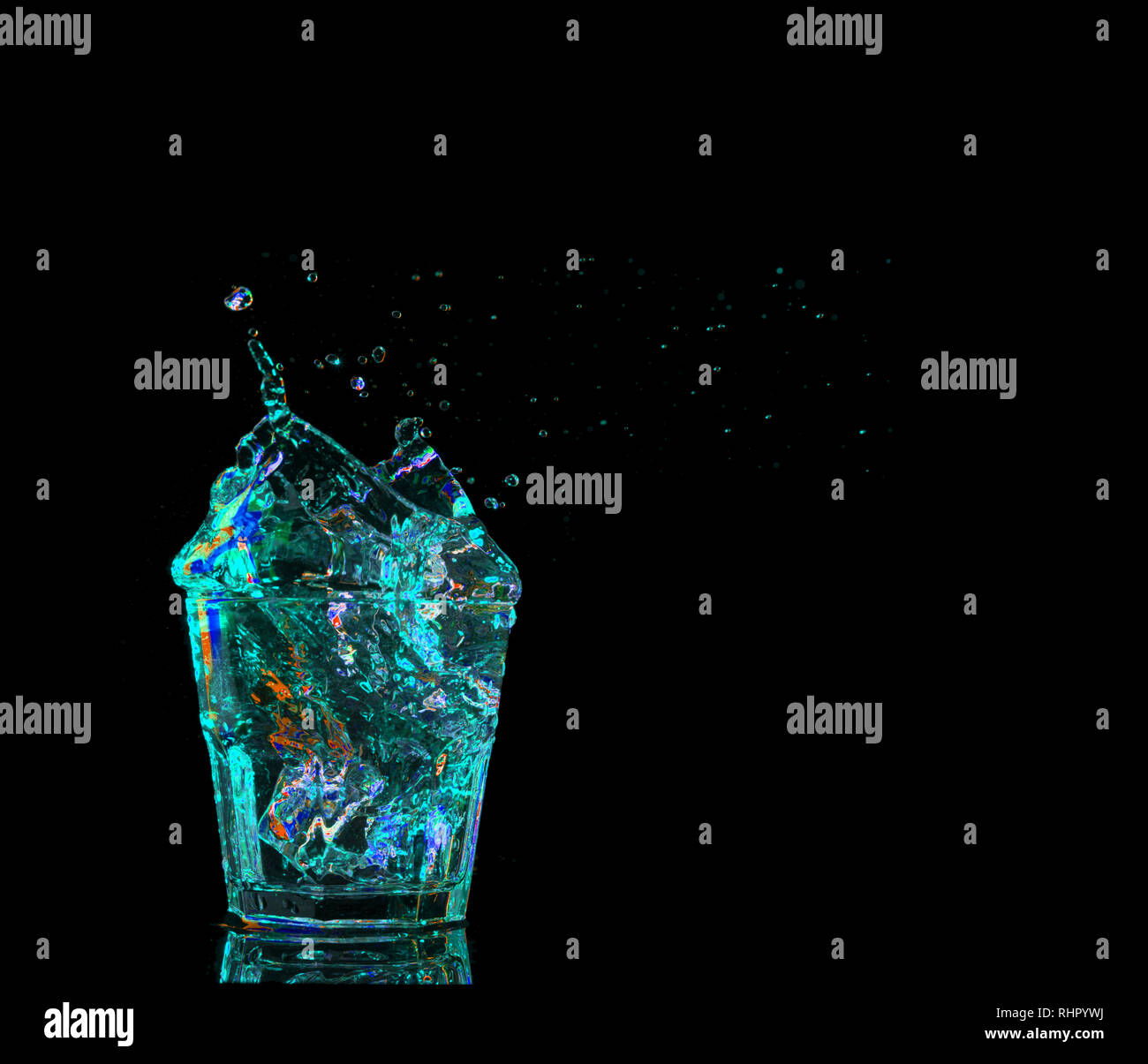 Bunten Cocktail aus Glas mit Spritzern auf dunklem Hintergrund. Party Club Unterhaltung. Mischlicht Stockfoto