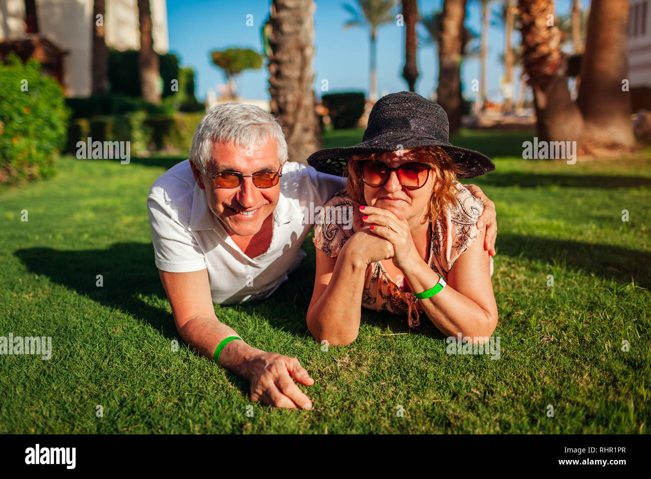 Senior Paar liegen auf Gras auf hotel Gebiet. Glückliche Menschen genießen Urlaub. Valentinstag Stockfoto Senior Paar liegen auf Gras auf hotel Gebiet. Glückliche Menschen genießen Urlaub. Valentinstag Stockfoto