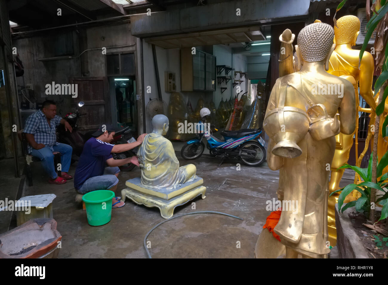 Ein Handwerker in einer Seitenstraße aus bamrung Muang Rd. in Bangkok, Thailand, legt letzte Hand an die Statue eines verehrten buddhistischen Mönch Stockfoto