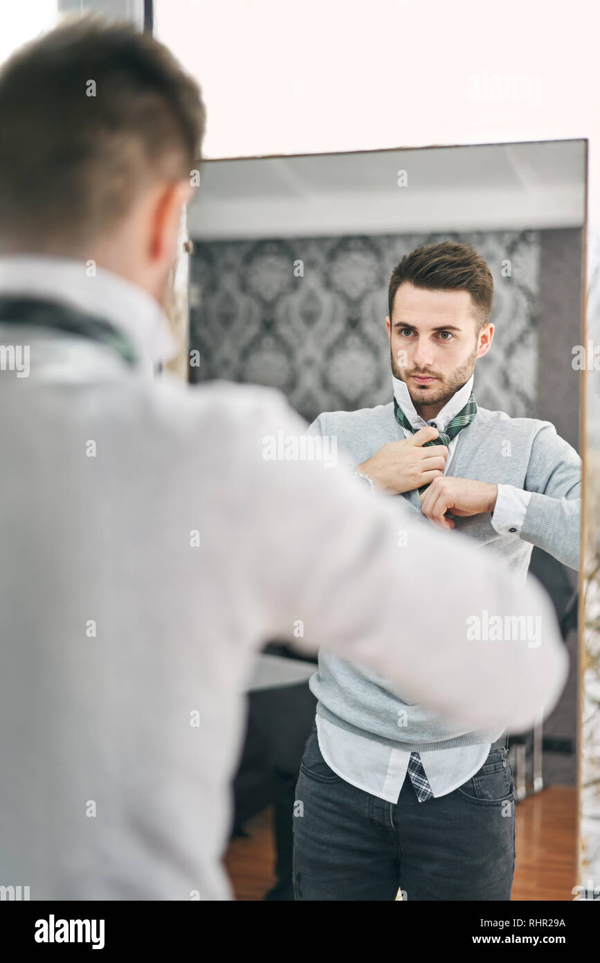 Hübscher junger Mann einstellen einen Riegel vor dem Spiegel. Shopping, Mode, Stil und Personen Konzept Stockfoto