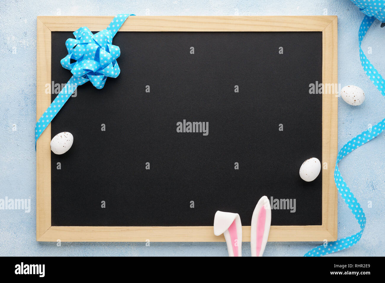 Ostern Hintergrund mit Funny Bunny Ohren, schwarzes Brett, Eier und Blue Ribbon. Urlaub Verkauf mockup mit Dekoration. Stockfoto