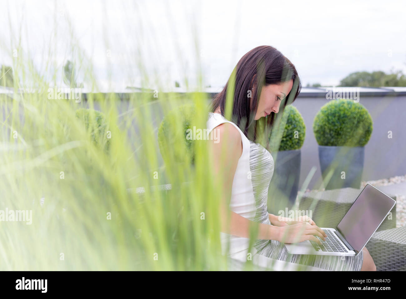 Professionelle mit Laptop beim Sitzen im Büro Terrasse Stockfoto