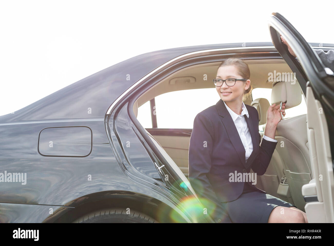 Zugeschnittenes Bild des Geschäftsmannes holding Autotür Kollege gegen Sky Stockfoto