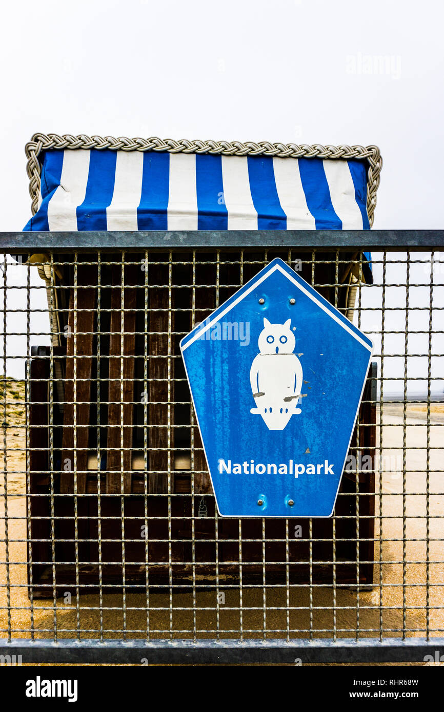 Typisch norddeutschen Strandkörben faltbares Dach und Wind Schutz der Seitenwände auf einer stelze hölzernen Plattform mit Blick auf Meer. Stockfoto