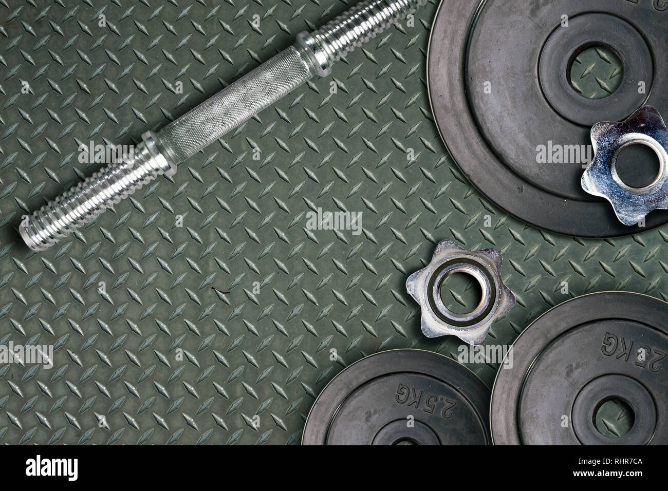 Hanteln und Gewichte sind auf dem Boden liegend in der Turnhalle. Langhantelset und Fitnessgeräten. Metall Lasten im Fitness Club Stockfoto