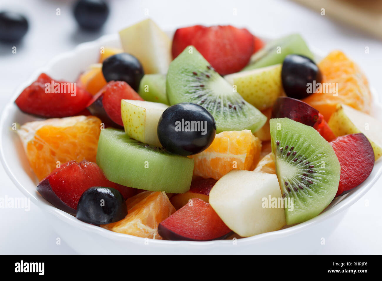 Frischer Salat aus Kiwis, Orangen, Pflaumen und anderen Früchten. Gesunde Lebensweise. Vegetarisches Essen. Stockfoto