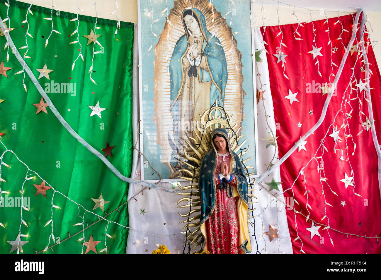 RIO LAGARTOS, MEXIKO - 14. Februar: Statue der Jungfrau Maria vor der Mexikanischen Flagge in einem Busbahnhof in Rio Lagartos, Mexiko am 14. Februar 2017 Stockfoto