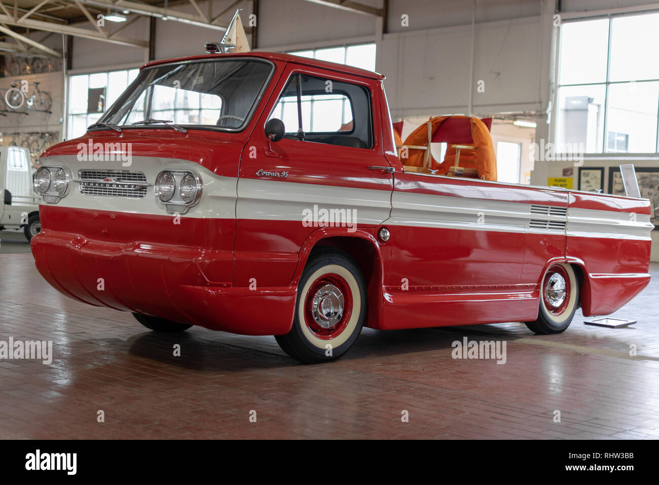 Ein 1963 Chevrolet Corvair 95 Rampside Pickup, die Farbe überwiegend rot mit weißen Streifen in der Mitte. Stockfoto