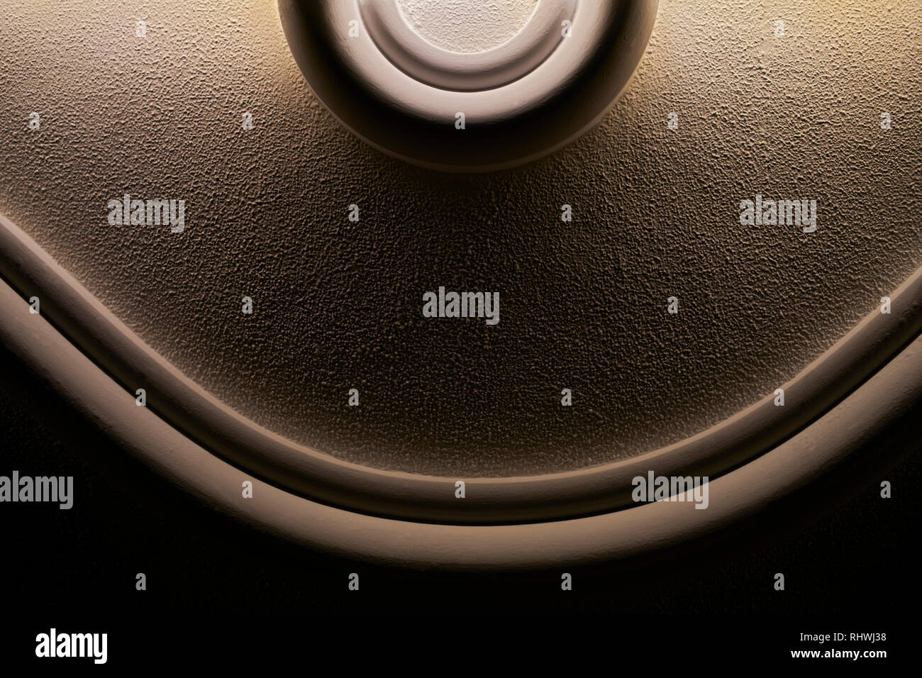 Schließen Detaillierte, vereinfachende rundlich geformtes Wand Design in Creme braune Farbe und schwarzem Hintergrund, mit indirekter Beleuchtung, in Asien Stockfoto