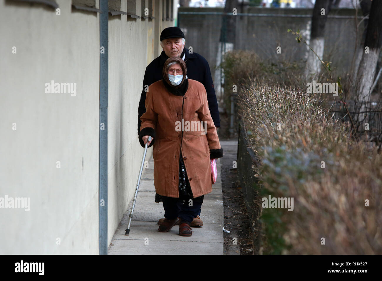 Bukarest, Rumänien. 4 Feb, 2019. Eine Frau geht mit Gesicht in Maske fallen auf einer Straße in Bukarest, Rumänien, Feb 4, 2019. Rumänische Ministerium für Gesundheit erklärt eine bundesweite influenza Epidemie vor kurzem und die Zahl der Todesopfer steigt von Tag zu Tag, bis zu 72 Opfer. Credit: Gabriel Petrescu/Xinhua/Alamy leben Nachrichten Stockfoto