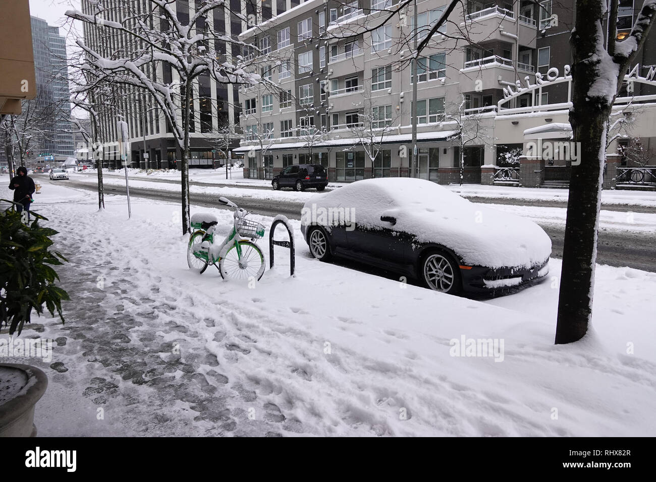 Bellevue, WA, USA. 4 Feb, 2019. Ein Auto und Kalk vermietung Bike im Schnee Stockfoto
