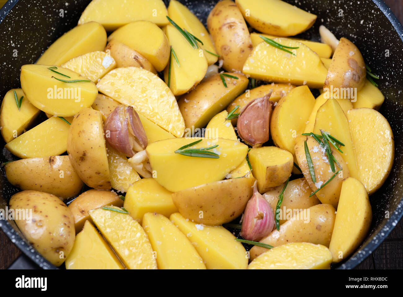 Kartoffelecken mit Rosmarin, Knoblauch und Salz in Gusseisen Skillet, Detailansicht Stockfoto