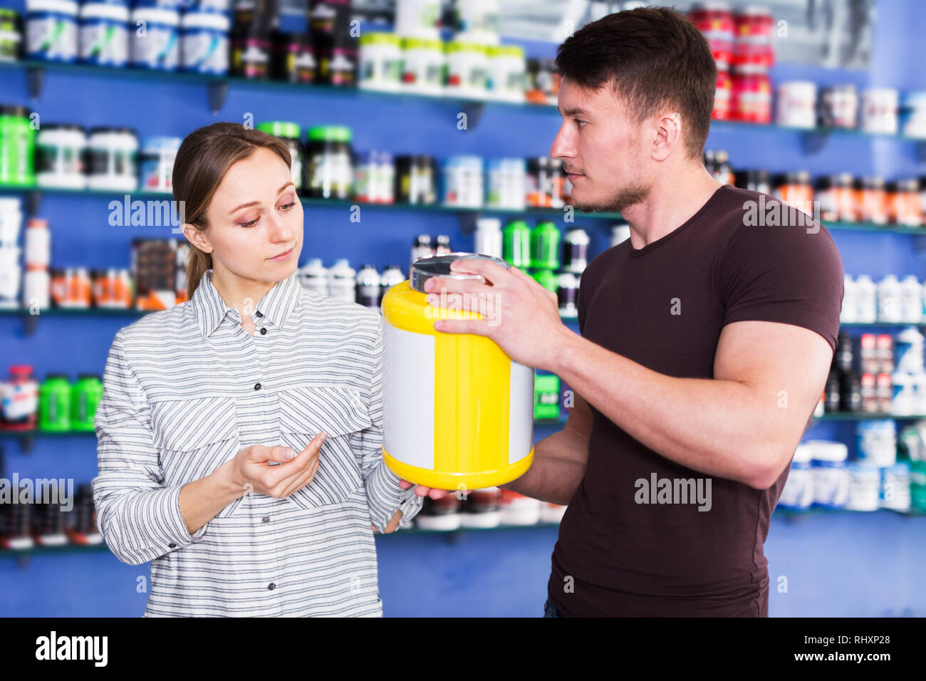 Junge positive körperlich fit Personen, die Sport Ernährung Produkte im Store Stockfoto