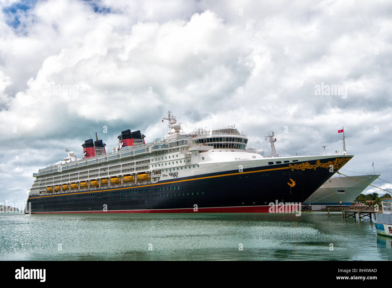 St. Johns, Antigua - Januar 15, 2016: Disney Wonder Kreuzfahrtschiff Sea Port an bewölkten Himmel angedockt. Disney Cruise Line. Sommer Urlaub und Erholung auf Kreuzfahrtschiff. Kreuzfahrtschiff Transport. Stockfoto