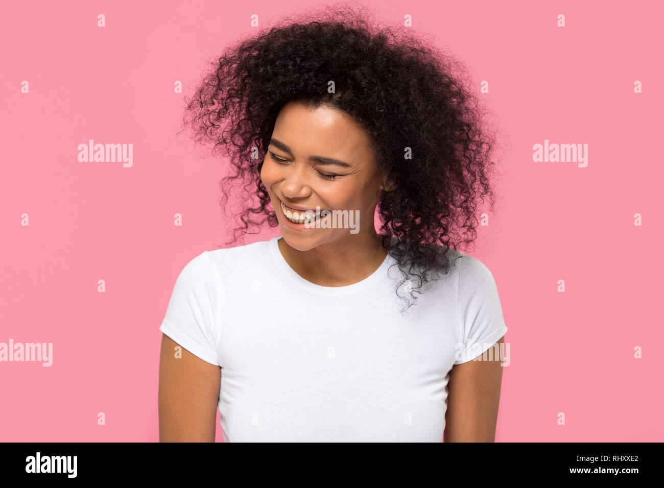 Gerne afrikanische amerikanische Mädchen lachend auf rosa Hintergrund isoliert Stockfoto