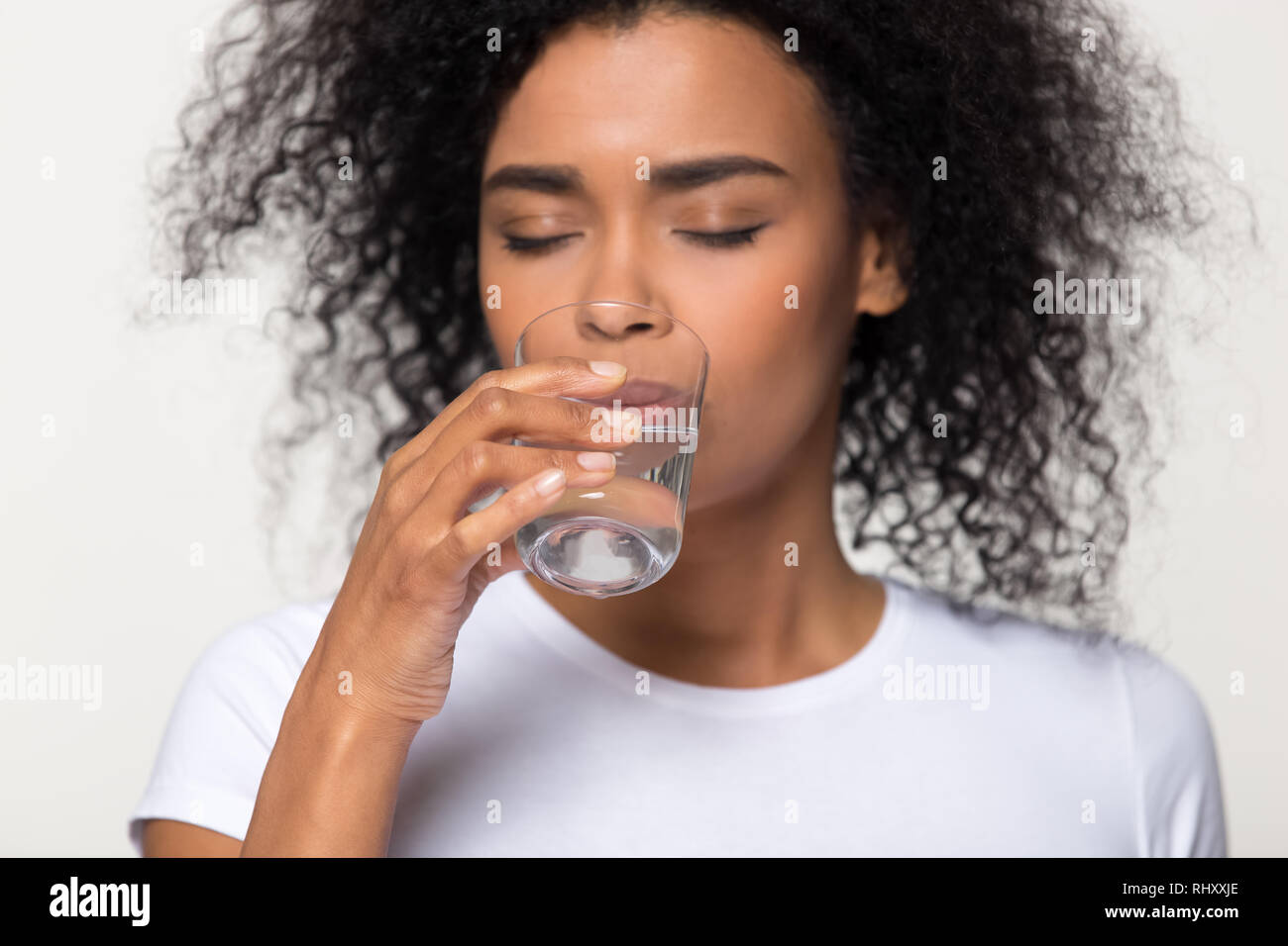 Gesund Durst afrikanische Frau Trinkwasser auf weißem Hintergrund Stockfoto