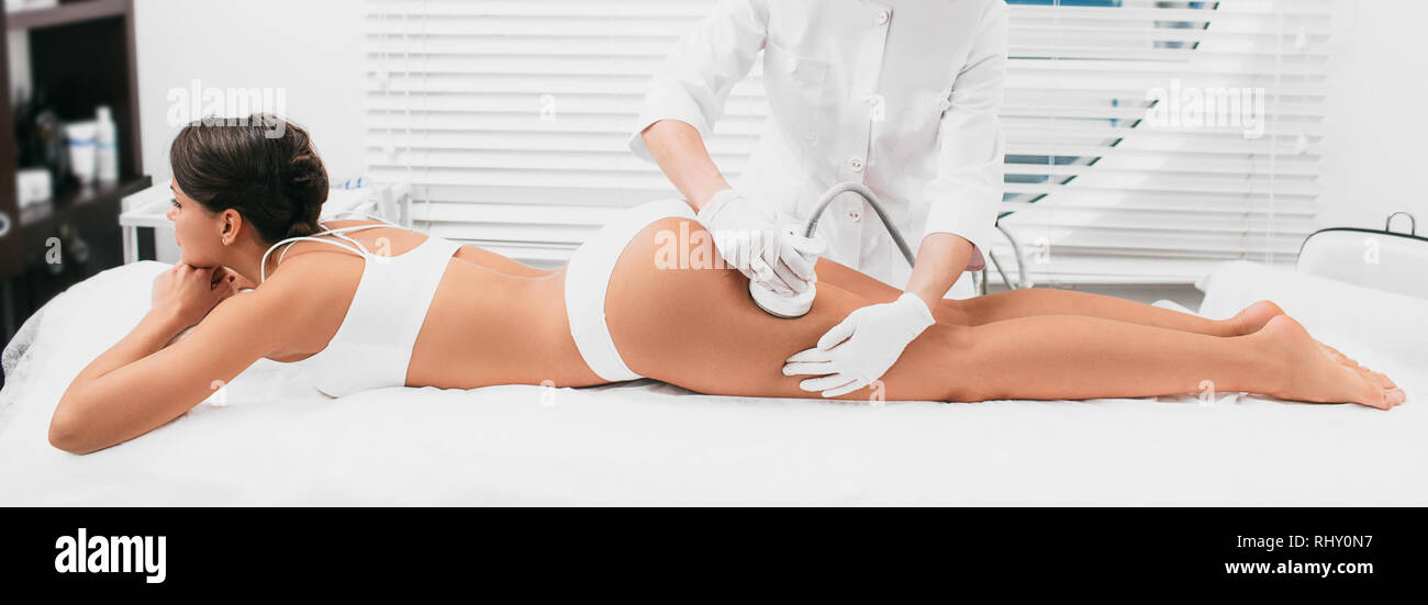Frau mit kavitation Verfahren auf Beinen und Po, Cellulite Behandlung im Beauty Klinik Stockfoto