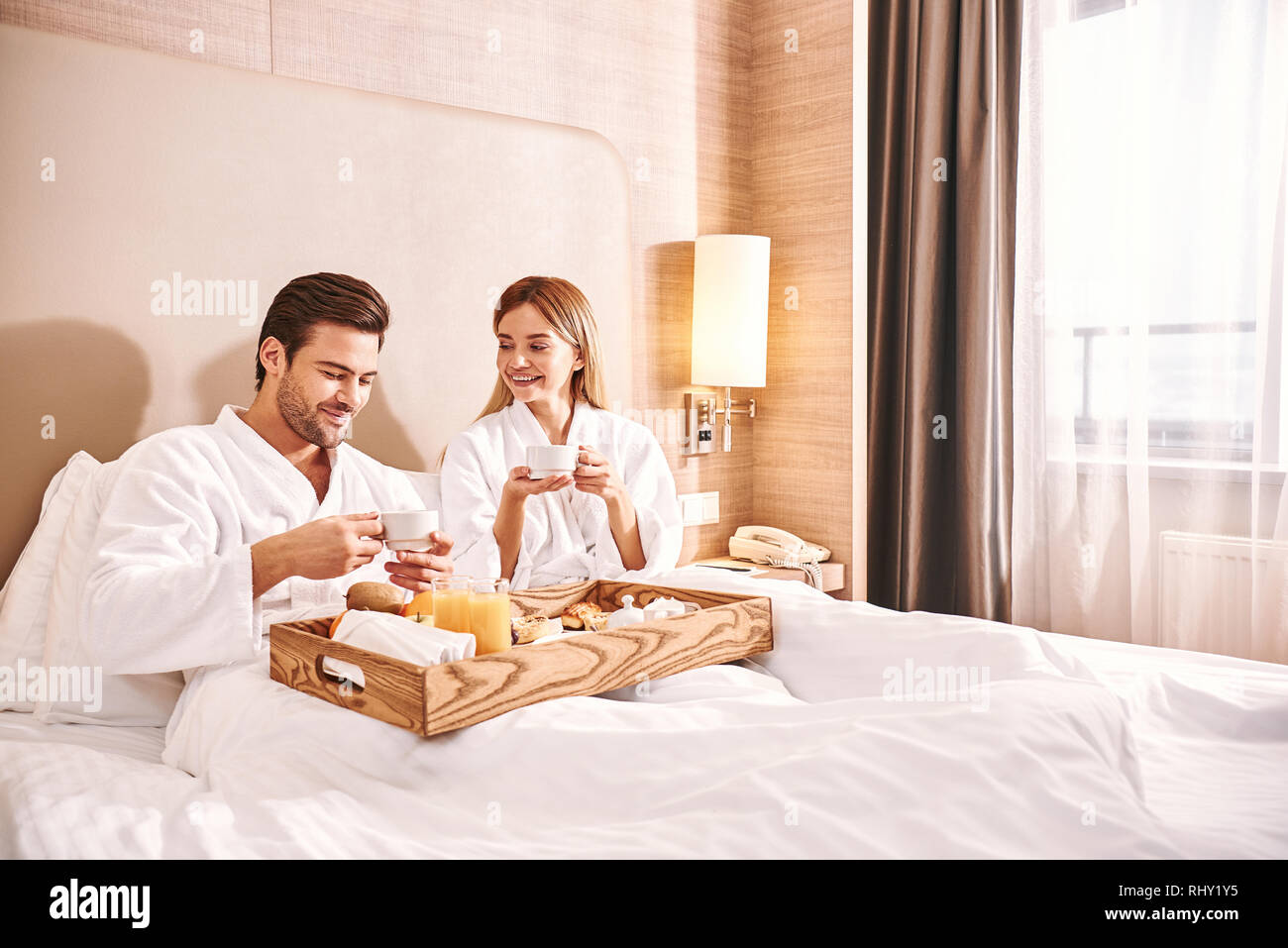 Verpflegung im Zimmer. Paar Essen im Hotel Zimmer Bett zusammen. Love Story. Kellner bringen Frühstück zu koppeln. Stockfoto