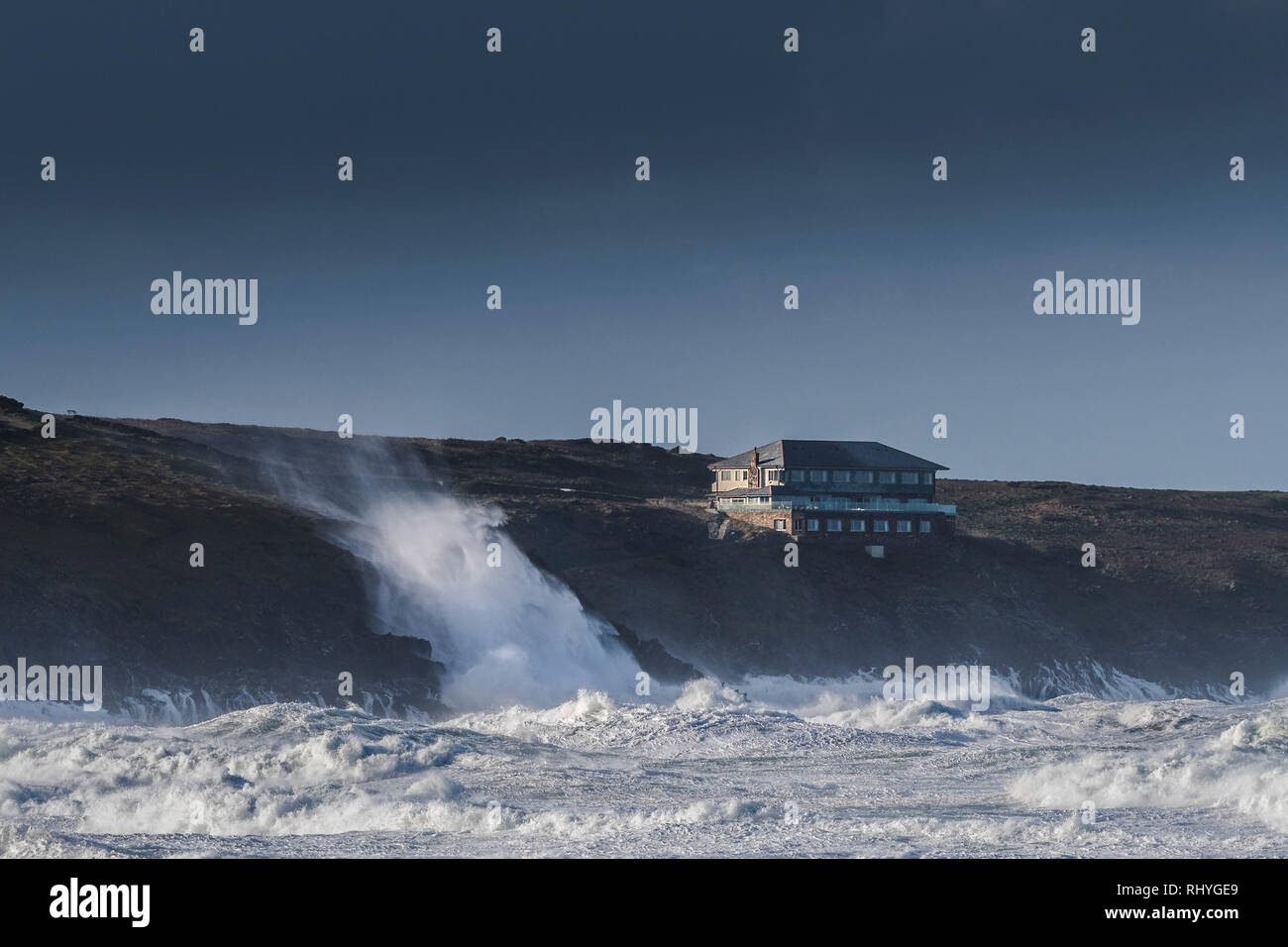 Die Lewinnick Lodge mit Blick auf das Meer im Winter Storm Wellen brechen in die Klippen unten. Stockfoto