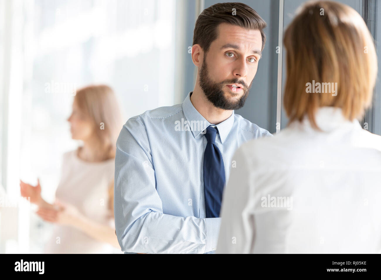 Ernsthafte Geschäftsmann hören Kollege im Büro Flur Stockfoto