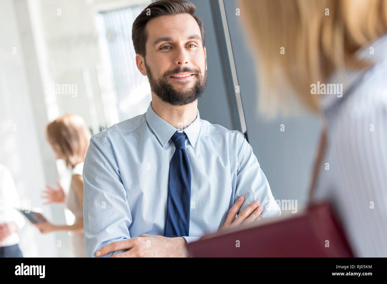 Lächelnd Geschäftsmann hören Kollege im Büro Flur Stockfoto