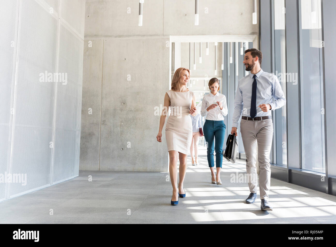 Fachleute sprechen bei einem Spaziergang in Büro Flur Stockfoto