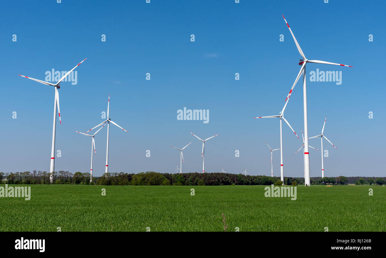 Windkraftanlagen, grüne Wiesen und blauer Himmel im ländlichen Deutschland gesehen Stockfoto