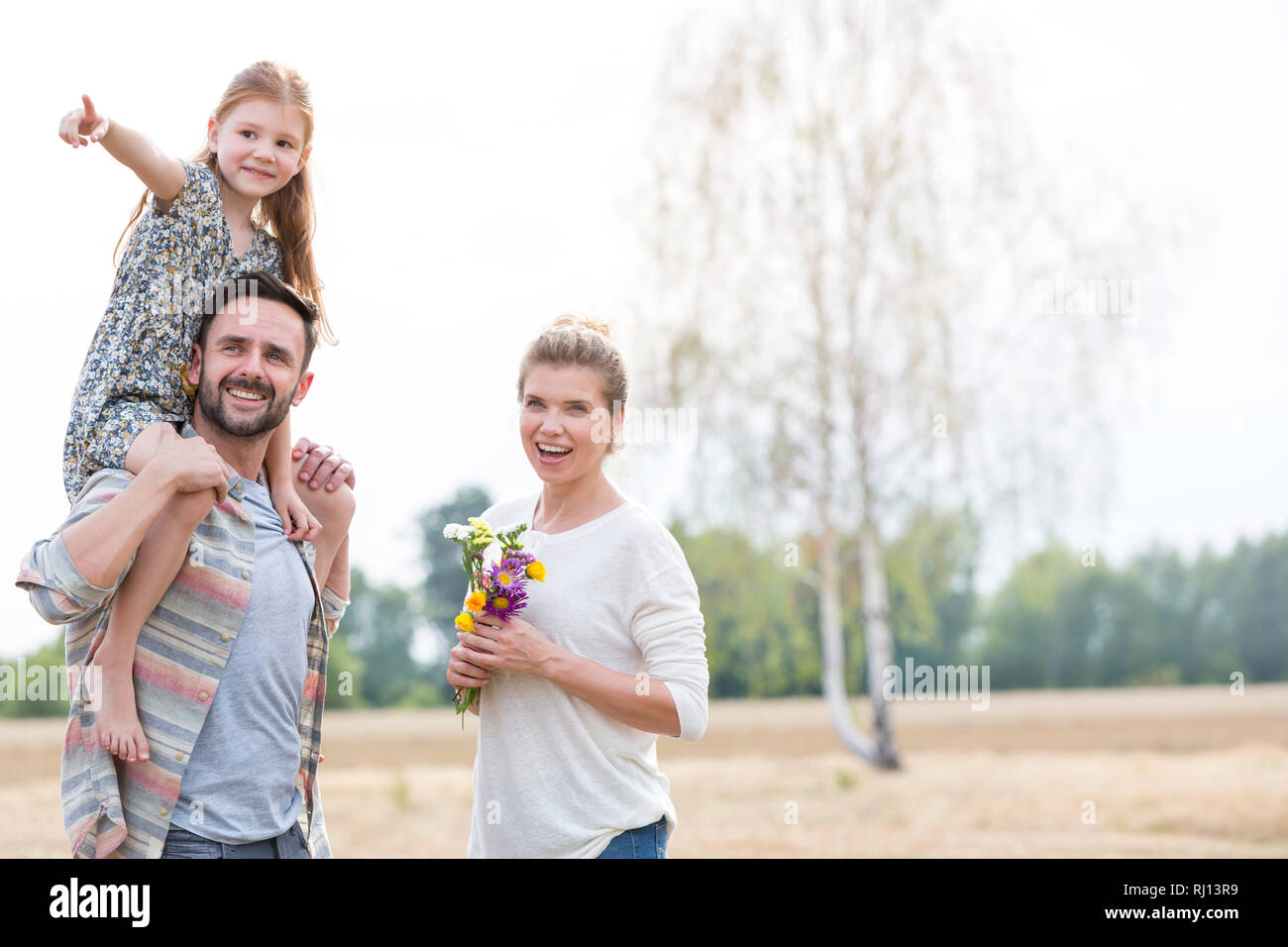Mädchen zeigen beim Zeigen auf glückliche Eltern auf der Farm Stockfoto