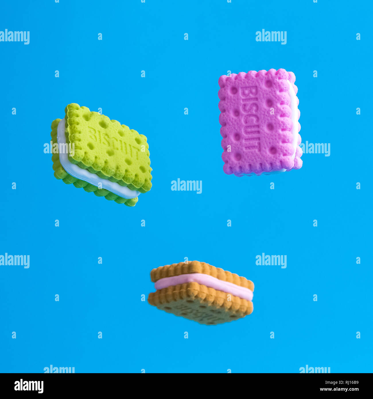 Bunte mini Kekse fallen oder schwebend gegen Pastell-blaue Hintergrund minimal süßen Speisen kreatives Konzept. Stockfoto