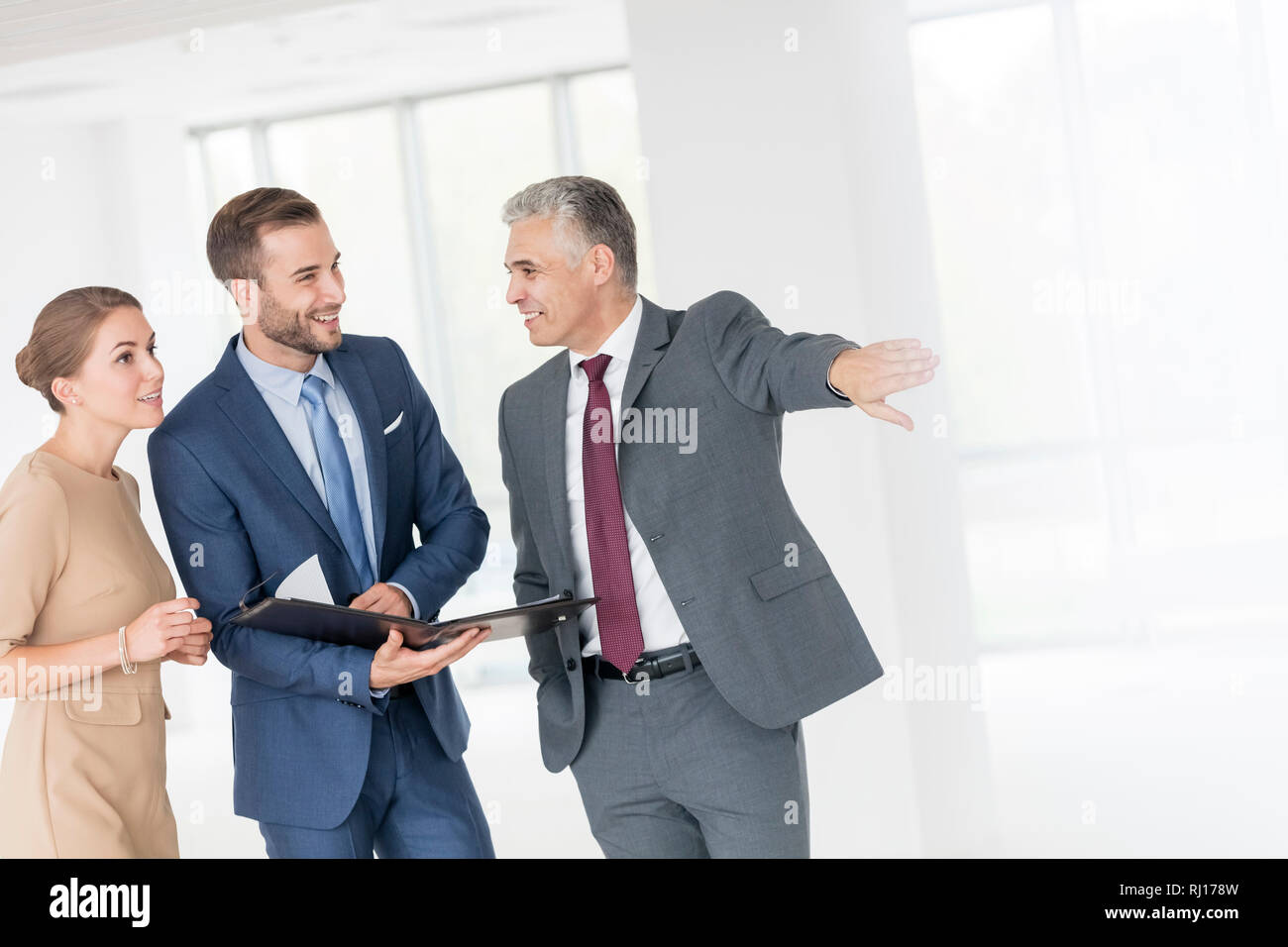 Lächelnd reife Geschäftsmann gestikulierend zu Kolleginnen und Kollegen im neuen Büro Stockfoto