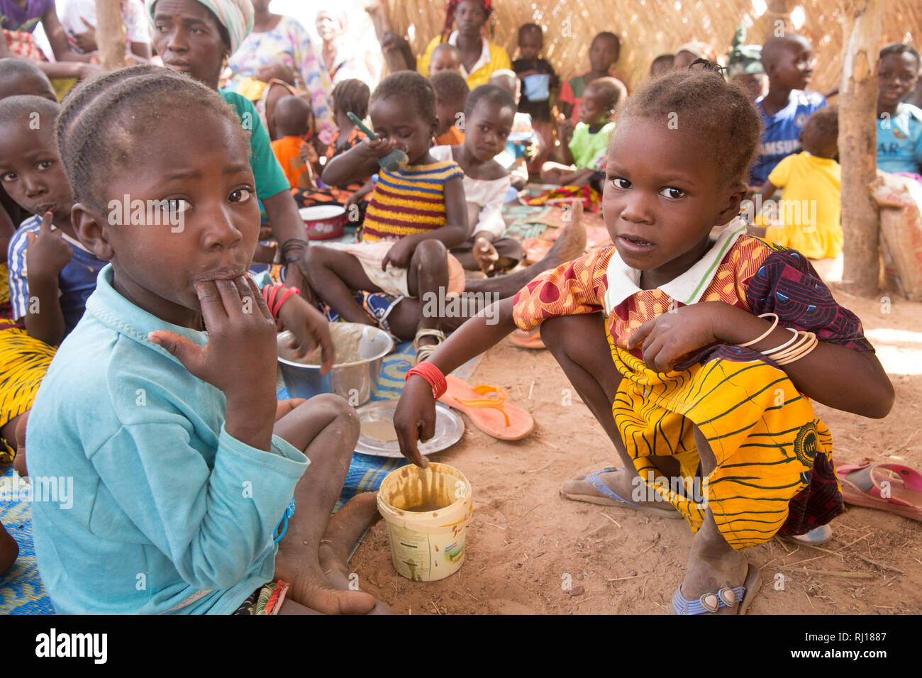 Samba Dorf, yako Provinz, Burkina Faso. Unterernährte Kinder essen nahrhaften Brei nach Gesundheit Arbeiter eine Demonstration der Methode. Stockfoto